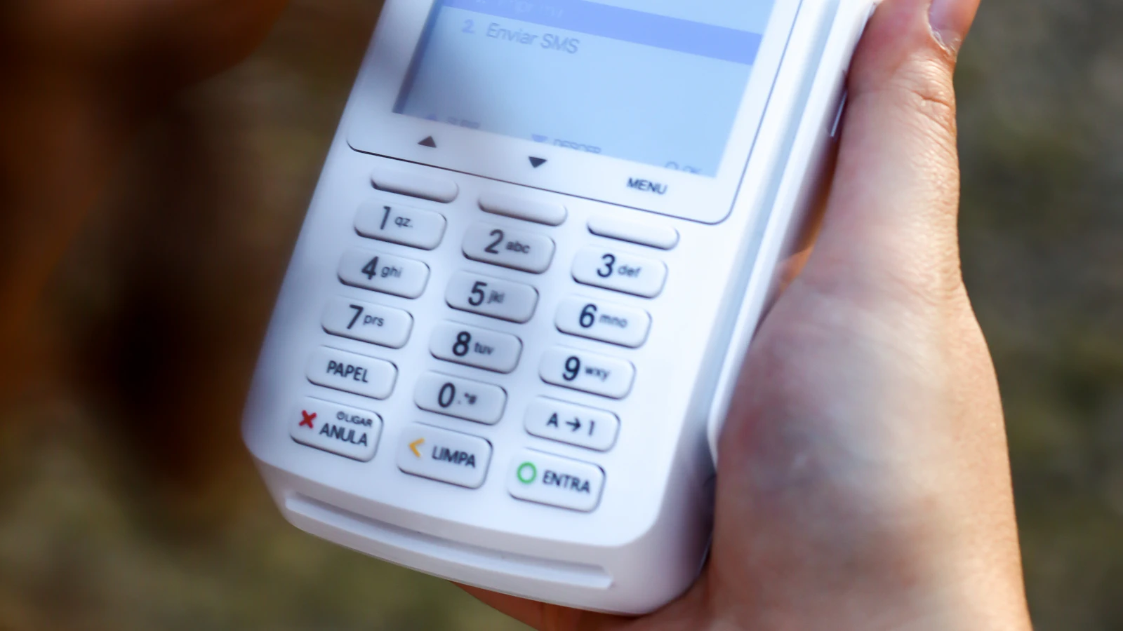 Bir elinde cep telefonu, diğerinde alışveriş fişi tutan kişi